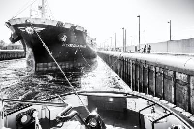 Tug in action at the locks of IJmuiden teaming up with linesmen ashore. 