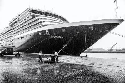 Linesmen mooring M/V Zuiderdam from HAL at the port of Amsterdam (IJmuiden) during heavy rain.